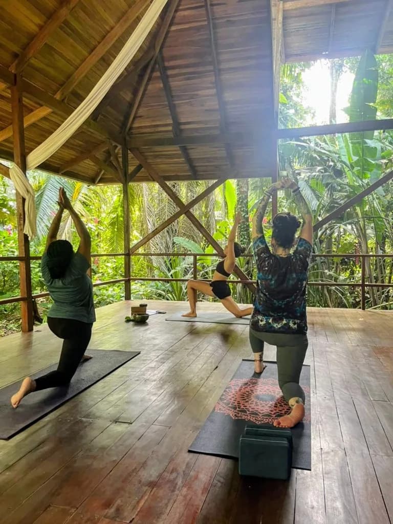 Trois femmes en fente basse dans le shala, face à la jungle