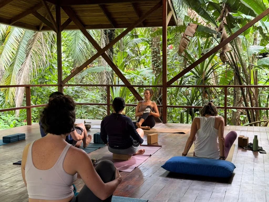 Marine guidant un cours de yoga dans le shala ouvert sur la jungle