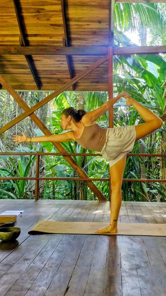Marine en Natarajasana sur la terrasse ouverte sur la forêt
